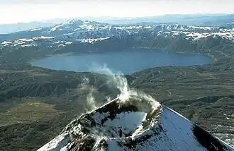 La caldera ricoperta da un lago dell'Akademia Nauk, qui vista dal nord, con il vulcano Karymskij sullo sfondo.