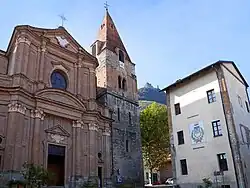 Chiesa di San Giovanni Vincenzo vista dall'omonima piazza, con la Torre Comunale e sullo sfondo la Sacra di San Michele.