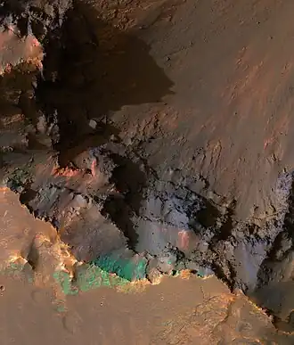 Bordo meridionale del Coprates Chasma, con larghezza di circa un chilometro. I colori all'IR sono stati intensificati per mostrare la cima della parte sud della valle, con vista verso le ripide pareti interne.