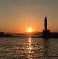 Tramonto visto dalla città con il faro in controluce