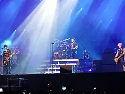 Una fotografia a colori dei membri dei Green Day in concerto