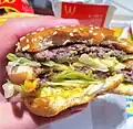 Un Big Mac di McDonald's in parte mangiato, che mostra il contenuto