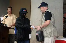 Un rappresentante del Dipartimento di Stato americano si congratula e offre un pagamento parziale a un informatore sotto mentite spoglie le cui informazioni hanno portato alla neutralizzazione di un terrorista nelle Filippine.