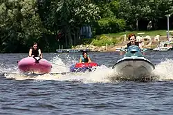 Slitta gonfiabile trainata dietro una moto d'acqua sul fiume Mississippi.