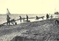 Fotografia storica di ricerche aurifere su sabbie di spiaggia (Alaska, USA).